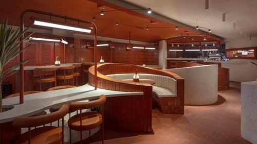 新德里的一家全天餐厅是一个充满火热的terracotta和奶油水磨石的漩涡仙境